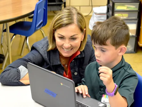 Gov. Reynolds works with student on laptop