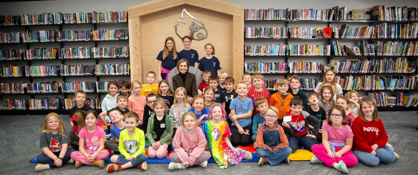 Gov. Reynolds posing with students in a library