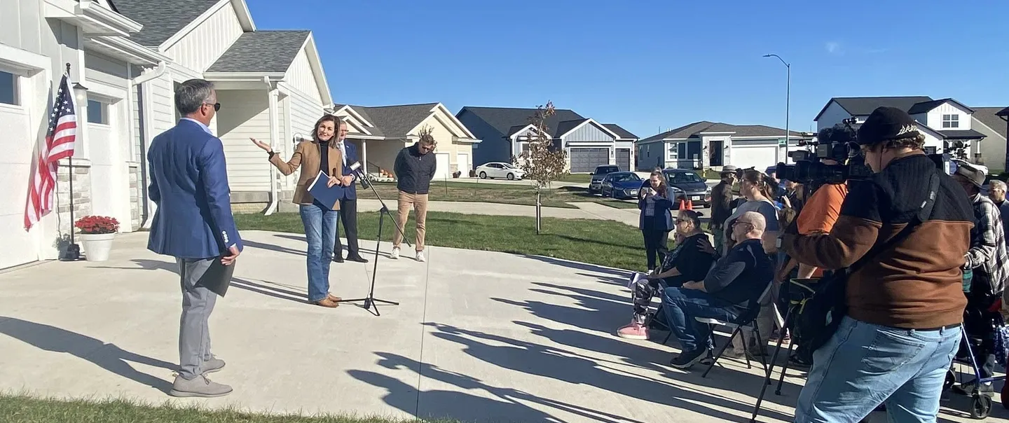 Governor Reynolds in front of houses
